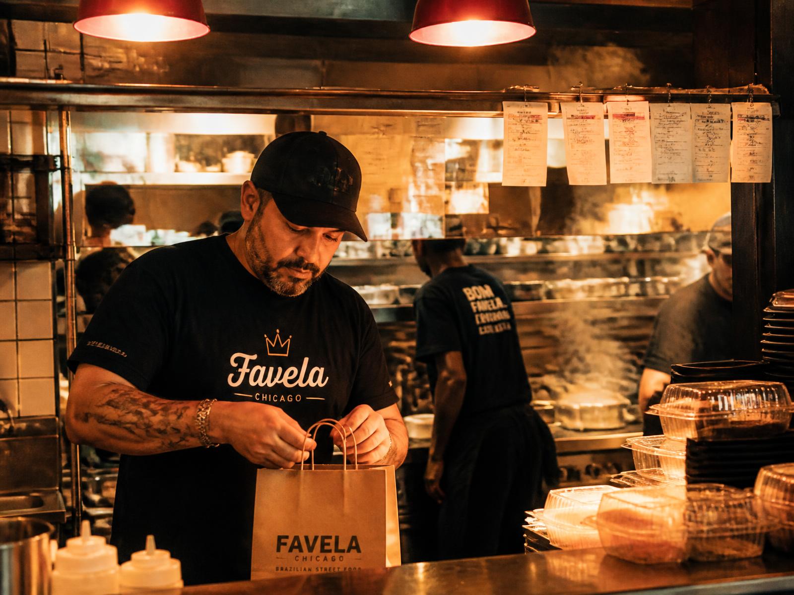 Dono de delivery embalando pedidos na cozinha do restaurante